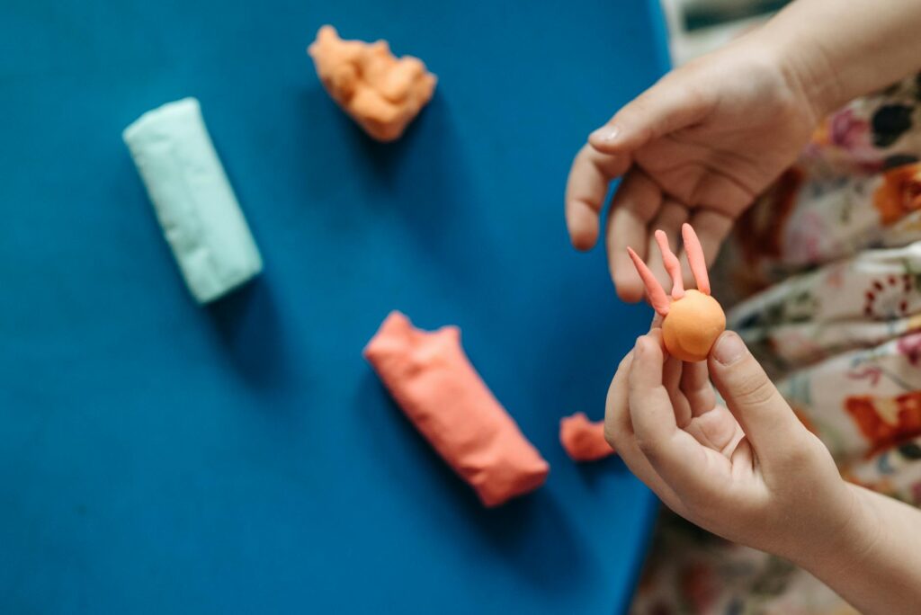 a kid forming shapes from a clay dough